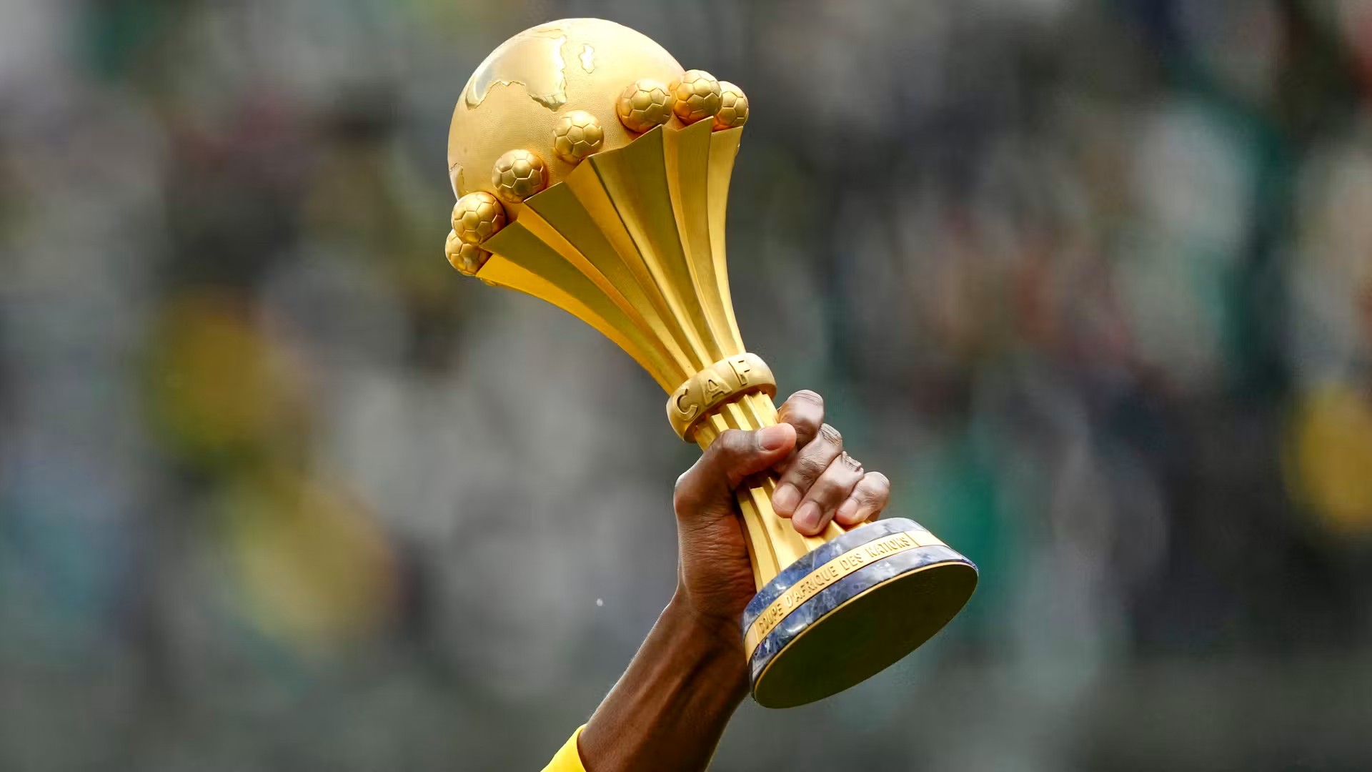 Le trophée de la CAN brandi par un joueur